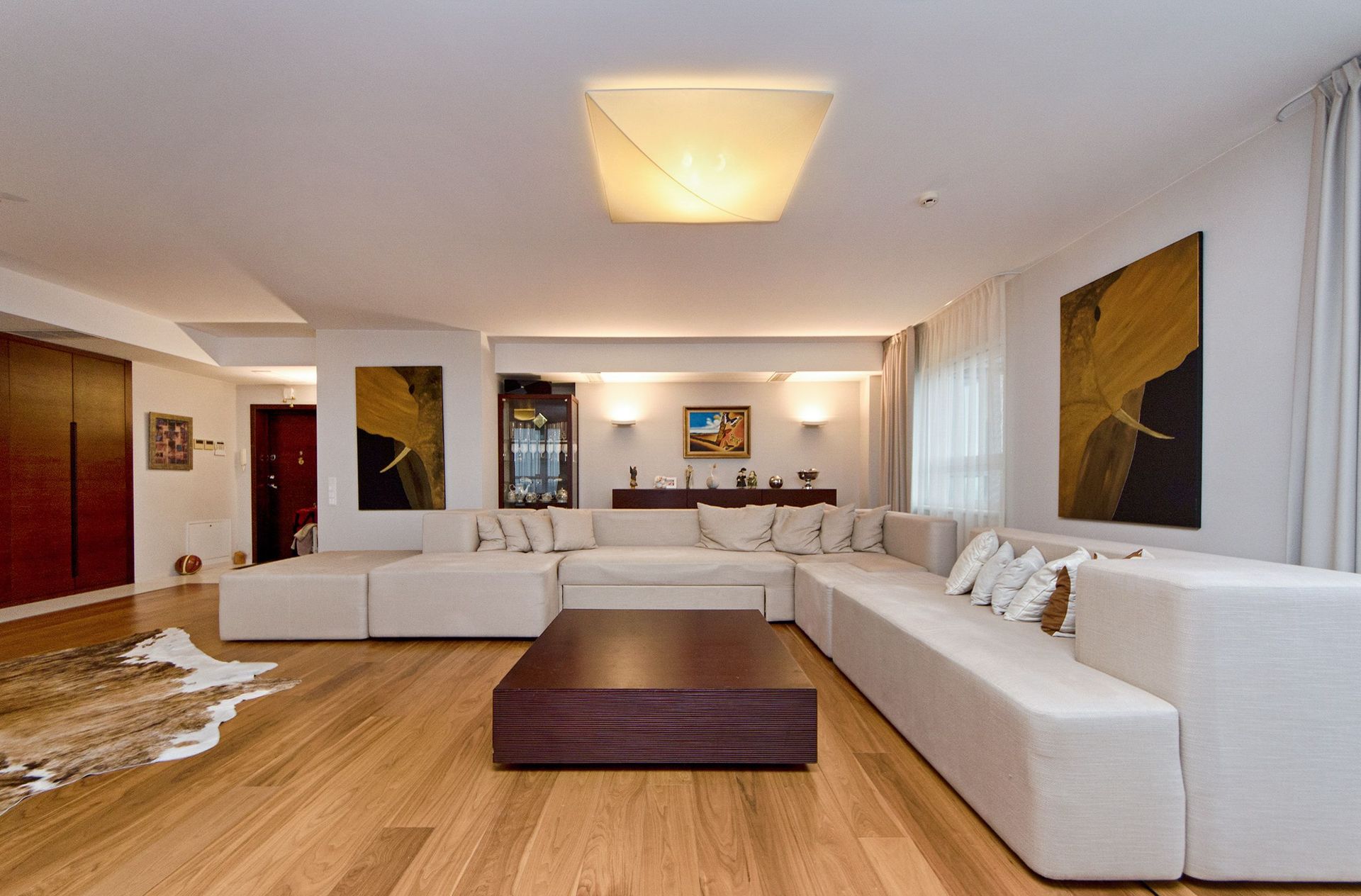 Spacious modern living room with stylish furniture and artistic decor.