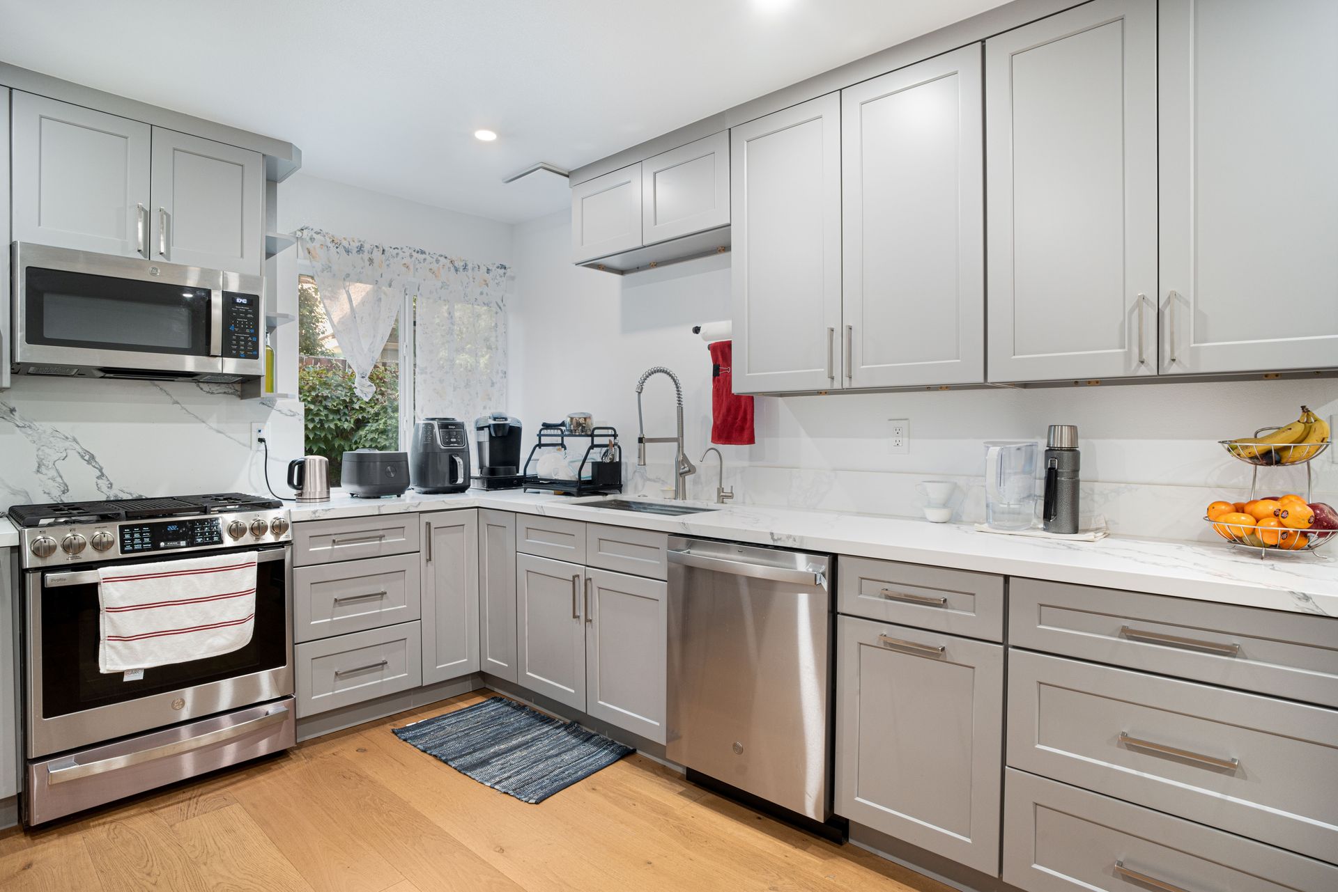 Sleek modern kitchen featuring stainless steel appliances and light grey cabinetry.